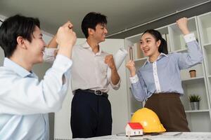 Collaboration and Achievement. A team of architects cheering after finalizing a successful project plan. photo