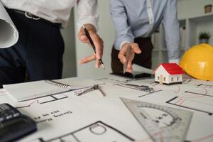 Architectural Planning and Drawing. Close-up of a team discussing blueprints and designs at a work table. photo