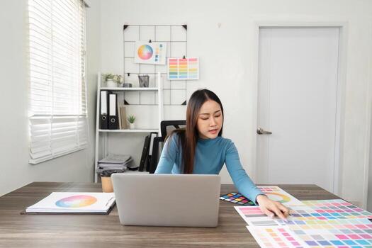 Color Theory and Professional Workspace. A designer immersed in color palette selection while utilizing a laptop for design projects. photo