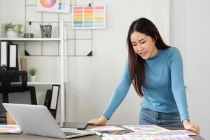 Creative Work and Design Process. A woman engaged in the creative design process, exploring color palettes and ideas in a modern workspace. photo