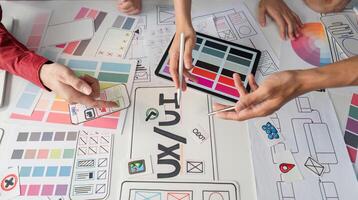 UX Design and Collaboration. Creative professionals brainstorming UIUX concepts on a design table. photo