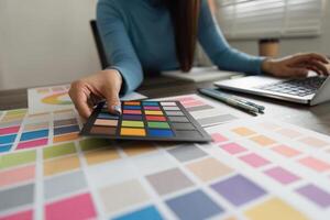 Palette Selection and Design Focus. A professional designer evaluating color options using swatches in a stylish workspace. photo