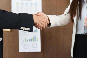 Business Agreement and Professional Interaction. Two professionals engaging in a handshake to finalize a partnership. photo