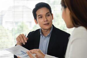 Client Consultation and Financial Discussion. A professional explaining financial data to a client in an office setting. photo