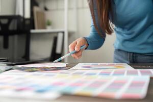 Design Process and Color Selection. A designer carefully evaluates color samples and palettes to enhance their project. photo