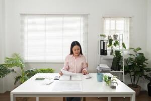 Home Office and Document Management. An individual sorting through paperwork while seated in a bright home office. photo