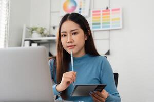 Color Selection and Design Process. A designer contemplating color choices using a tablet and swatches in a modern workspace. photo