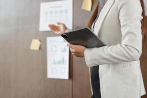 Business Communication and Strategy. A woman presents key performance indicators in a project management context, highlighting corporate priorities. photo