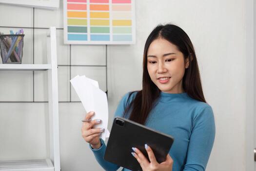 Palette Evaluation and Artistic Inspiration. A designer reviewing color choices while engaging with a digital device for creative direction. photo