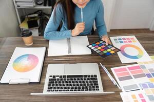 Creative Exploration and Color Palettes. A design enthusiast engaged in color palette selection using color charts. photo