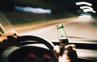 Risks of impaired driving highlighted by a nighttime adventure with a beer bottle photo