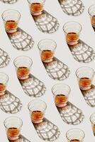 Transparent Glasses with alcohol drinks, shadow at sunlight on beige concrete table, minimal style, creative aesthetic pattern shiny glass sparkling at natural light, summer strong drink, above photo