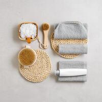 Natural spa, wellness, bath accessories as minimal flat lay pattern, sea salt flakes in wooden bowls, soft gray towels, brush, reusable cotton pads, grey conctrete background, top view neutral colors photo