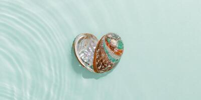 Two natural seashells forming heart shape, sea water gentle ripples cast soft, wavy shadows on clean, light-blue background, summer, serene, minimalist aesthetic banner. Feelings of love, tranquil photo
