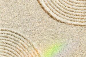 Top view pattern in Japanese Zen Garden with closeup lines on sand, meditation and relaxation vibes. Aesthetic minimal sandy background with colorful rainbow reflections, beige monochrome color photo