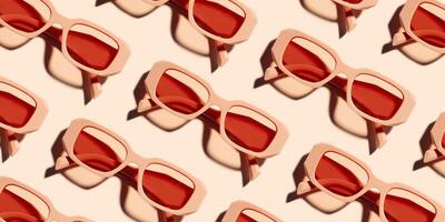 Banner with Pattern of pink color sunglasses on pale pink background at sunlight with shadow. Summer fashion eyeglasses with rose colored glass. Summer vacation, rest concept. Minimal style top view photo