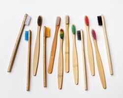 Top view of eco friendly bamboo toothbrushes on grey white, Natural organic personal accessories for tooth care, zero waste, no plastic concept, minimal style aesthetic pattern, colored toothbrush photo
