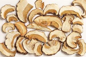 Minimal food pattern beige monochrome colored from dried slices of porcini, dehydrated food boletus mushrooms, top view, aesthetic texture flat lay. Natural forest white mushroom, healthy eating photo