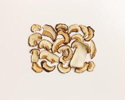 Minimal food pattern beige monochrome colored from dried slices of porcini, dehydrated food boletus mushrooms, top view, aesthetic flat lay. Natural forest white mushroom, healthy vegetarian eating photo