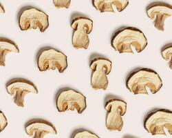 Minimal food pattern beige monochrome colors from dried slices of porcini, dehydrated food boletus mushrooms, top view, aesthetic texture flat lay. Natural forest white mushroom, healthy eat photo