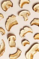 Minimal food pattern beige monochrome colors from dried slices of porcini, dehydrated food boletus mushrooms, top view, aesthetic textured flat lay. Natural forest white mushroom, healthy eating photo