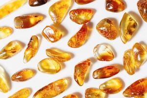 Amber stones on light background, transparent stone yellow beige gradient color. Natural gemstone mineral healing crystal. Top view Amber textured fon. Nature gems, pieces ancient resin. photo