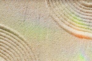 Zen lines on sand, beautiful sandy texture with rainbow flare. Natural sand background for spa wellness, concept for relaxation balance and harmony, spirituality. Minimal aesthetic top view photo