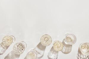 Summer party wine drinks flat lay, wine glasses with white sparkling wine and sunshine shadow on light table. Minimal pattern with beautiful wine glasses, above view still life, beige golden color photo