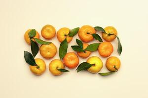 Fresh orange yellow tangerines with green leaves on beige table background, minimal pattern. Citrus fruits mandarines as trend food layout, flat lay style, neutral color, christmas fruits tangerines photo