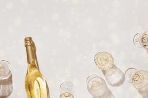 Top view white sparkling wine in different glasses of wine, stemmed glass with sun shadow and glare on light beige background. White wine tasting concept flat lay, copy space. Summer drinks photo