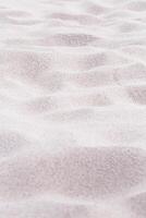 Beige pink Sand texture natural background. Close up waves pattern on sand dunes, minimal nature vertical backdrop. Summer and travel, spa and relaxation concept. Selective focus. photo