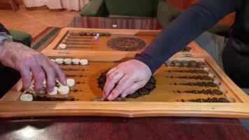 Backgammon players place their stones in their starting positions after the game is over. Arrangement of positions on the board of a wooden board game. Position of stone in backgammon video