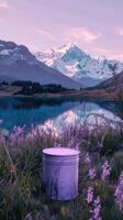 A white bucket sitting in front of a lake with flowers photo