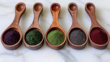 Five Wooden Spoons Filled with Vibrant Superfood Powders Acai Spirulina Matcha Chia Seeds Beetroot photo
