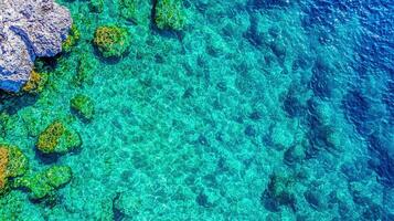 Stunning Aerial View of Crystal Clear Turquoise Ocean Water Over Rocky Seabed photo