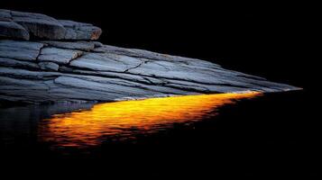 Dramatic Sunset Reflection on Rocky Coastline Golden Hour Water and Grey Stone photo