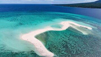 Vibrant drone view of a sandbar island with pristine white sand and azure waters, with a volcano in the background, Philippines. video
