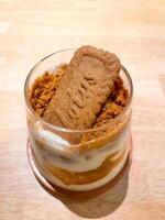 A cookie in a glass with a spoon on top photo