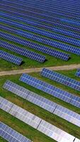 Solar panels farm field of green renewable energy. Powerful station with solar panels generates electric current with help of sunlight on field. Orbital view. Vertical video