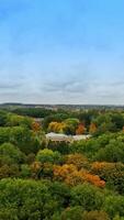Approaching the beautiful palace in the lush greenery of the park. Cloudy sky at backdrop. Aerial view. Vertical video