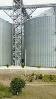 Aerial view. Plant for storage and processing of grain. Metal Grain Elevator Vertical video