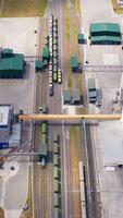 Modern industry on field. Grain processing factory with cargo trains and large metal grain elevators. View from above. Vertical video