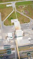 Construction of a new granaries on field. Grain elevators for keeping crop. Building of a modern agricultural complex. Top aerial view. Vertical video