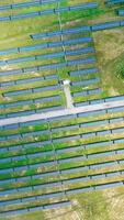 Ecological power plant in summer. Top view on the solar panels on the field. Renewable energy. Alternative source of electricity. Aerial view. Camera moves around. Vertical video