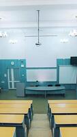 Empty lecture hall in the university. Beautiful classroom in the educational centre with modern interior. Conference hall with blackboard and modern equipment. Panoramic view. Vertical video