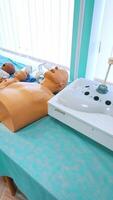 Mannequins on the table for medical training. Plastic dolls and parts of patient's body models for teaching practice in the university. Vertical video