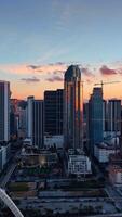 Skyscrapers in the rays of setting sun. Miami downtown at the backdrop of beautiful sky. Aerial view. Vertical video