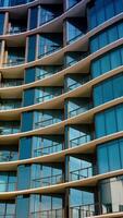 Beautiful facade of multi-storied apartment block with mirror windows. Low angle view on the building in Miami, Florida, USA. Vertical video