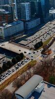 Drone flying above the busy highway in Atlanta downtown. View on the traffic in metropolis on sunny day. Vertical video