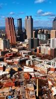 Flight above the low-rise and high-rise architecture of American city. Approaching skyscrapers in Atlanta downtown. Vertical video